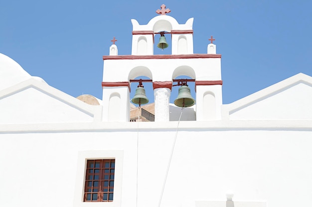 Torre do sino da igreja grega com céu azul ao fundo Oia Santorini Grécia
