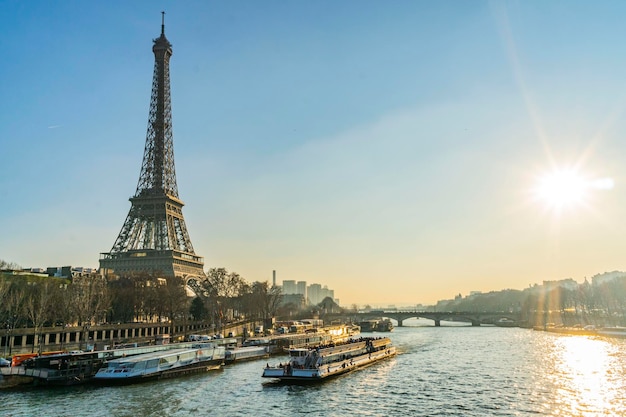 Torre Eiffel junto al río en la ciudad contra el cielo durante la puesta de sol