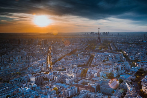 Torre Eiffel con paisaje urbano contra un cielo nublado durante la puesta de sol