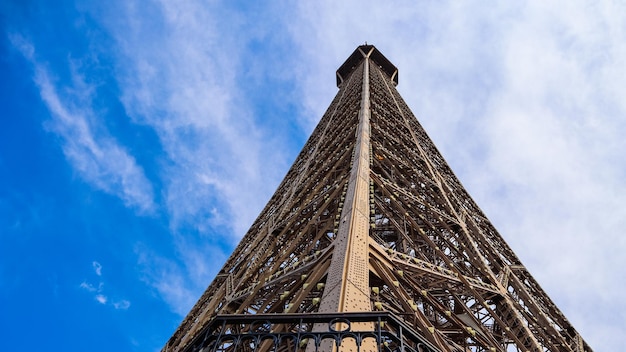 Torre eiffel en parís francia contra el cielo azul con nubes abril