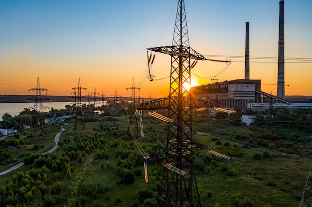 Torre eléctrica de alto voltaje Silueta en las torres de energía de la hora de la puesta del sol en el fondo de la hora de la puesta del sol Enfoque selectivo