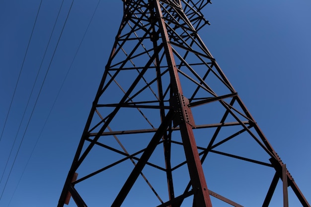 Torre eléctrica de metal de alto voltaje sobre fondo de color azul