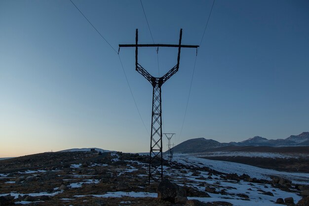 Torre elétrica no inverno ao pôr do sol
