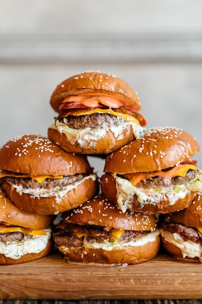 Torre de hamburguesas con carne marmoleada de ternera pepinos encurtidos queso chkdder tomate salsa tártara de cebolla caramelizada