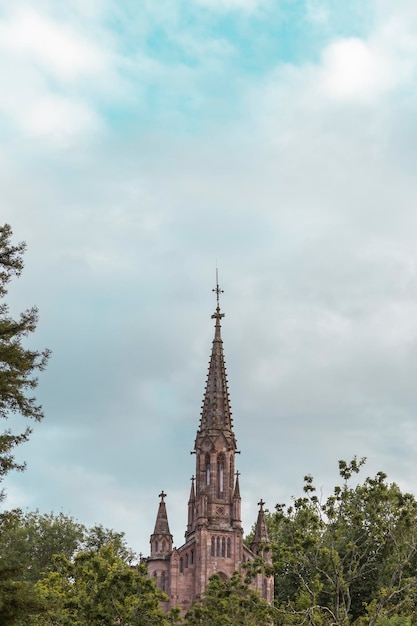 Torre de la iglesia que sobresale de los árboles