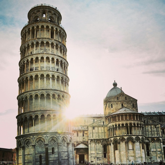 Torre inclinada de Pisa y edificio histórico contra el cielo