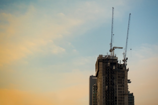 Foto torre industrial da construção da construção no fundo ajustado do céu do sol.