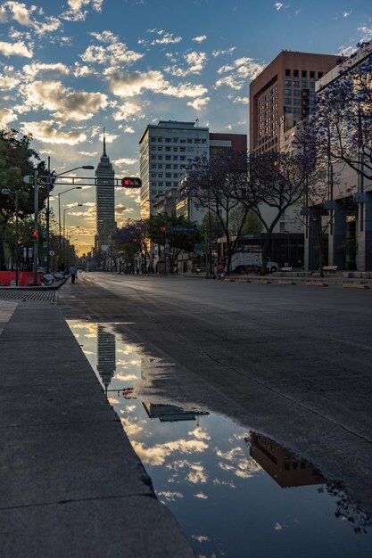 Foto torre latinoamericana reflejo en el charco en la calle