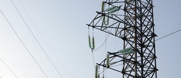 Torre de líneas eléctricas contra el cielo azul.