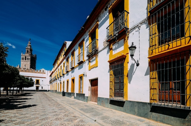 Torre moura giralda da catedral de sevilha com edifícios tradicionais em um pátio no real alcazar sevilla andaluzia espanha