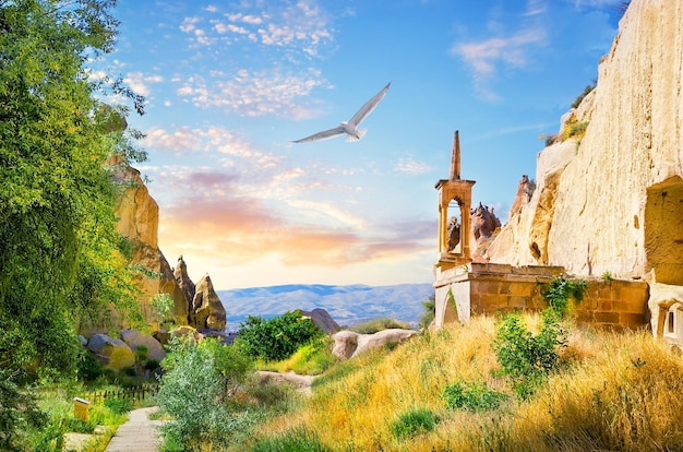 Foto torre de observación en el monasterio de roca del valle de zelve y gaviota en el cielo