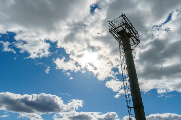 Torre de pararrayos de hormigón armado en el territorio de la empresa y una plataforma para dar servicio a los sistemas de telecomunicaciones Una escalera de hierro estrecha para subir a un empleado a la torre