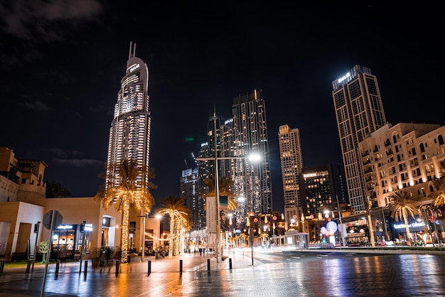 una torre del reloj está iluminada por la noche en una ciudad