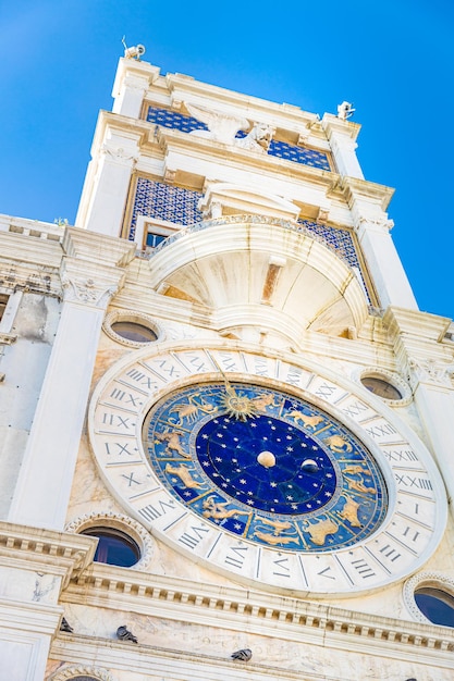 Una torre de reloj con un gran reloj azul que dice los números romanos.