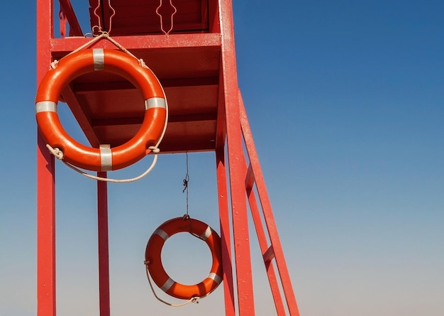 Foto torre de rescate roja con un salvavidas contra el cielo azul