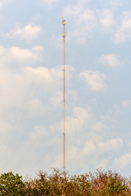 Torre de señal electrónica y nubes