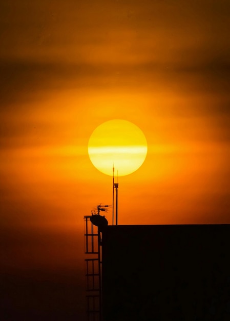 Foto torre de silueta contra el cielo dramático durante la puesta de sol