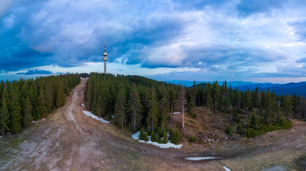 Torre Snezhanka no vale das montanhas e florestas de rhodope contra a vista superior do panorama das nuvens