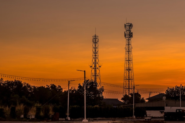 Torre de telecomunicaciones de siluetas al amanecer y cielo crepuscular