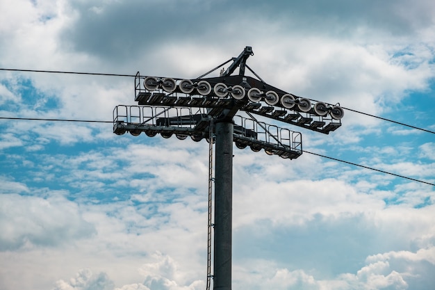 Torre del teleférico contra el cielo azul y las nubes