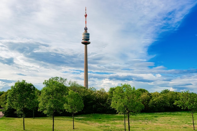 Torre de televisión Donauturm Danube en el distrito de Donaustadt en Viena en Austria. Antena de televisión y el parque. Paisaje urbano y paisaje con árboles verdes y hierba en Wien en Europa