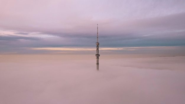 La torre de televisión mira desde las nubes al atardecer