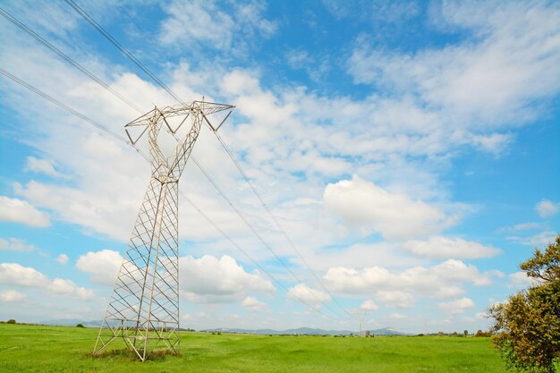 Torre de transmisión en el campo bajo un cielo azul