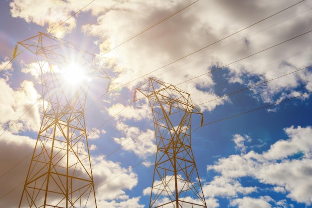 Torre de transmisión de la línea eléctrica aérea de la torre de electricidad al atardecer cielo sol nubes líneas eléctricas