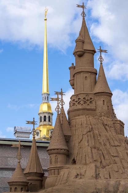 Torres de un castillo de arena y la torre de la Catedral de los Santos Pedro y Pablo en San Petersburgo, Rusia