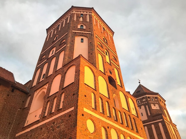 Torres e pináculos de um antigo e belo castelo medieval de pedra contra um céu azul