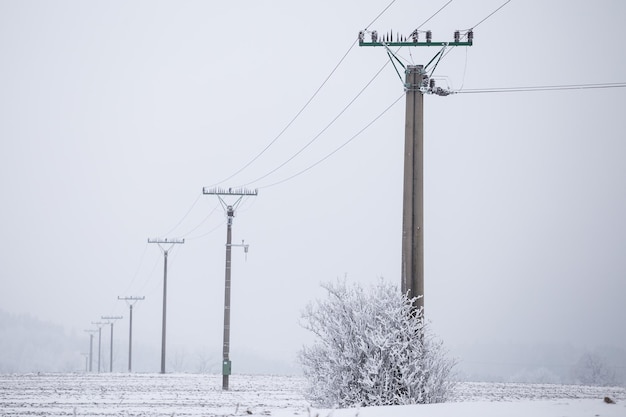 Torres eléctricas cables de alta tensión en invierno cubierto de nieve y hielo