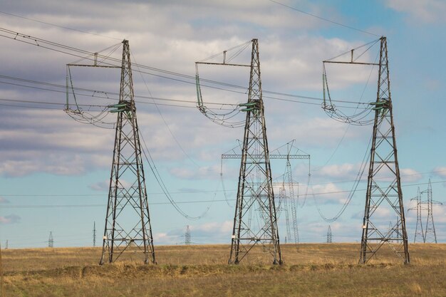 Torres y líneas de electricidad en el campo de verano, día soleado, telefoto