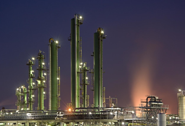 Torres de refinería con cielo púrpura