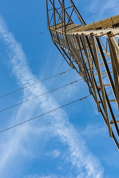 Torres de transmisión de electricidad o pilones con cielo nublado en el fondo