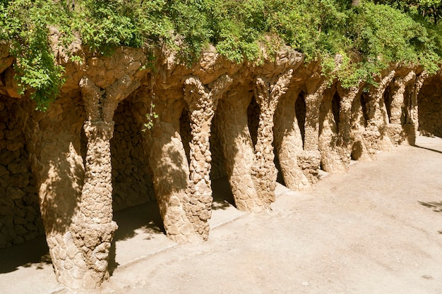 Torsión de pilares de roca con plantas verdes arriba dentro del famoso Parque Güell de Barcelona