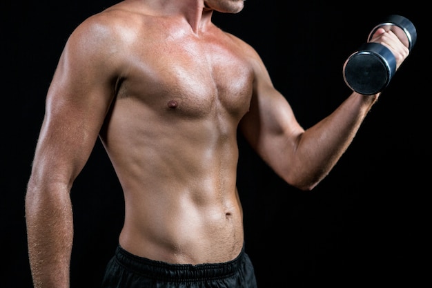 Torso de atleta sin camisa trabajando con mancuernas