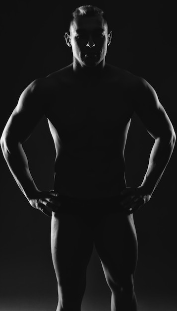 El torso de un culturista masculino atractivo sobre un fondo negro Foto de atleta brutal en el estudio