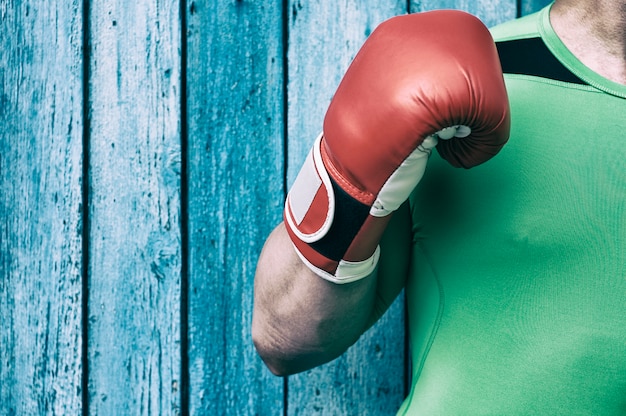 Torso de um homem e um homem da mão direita em luvas de boxe vermelhas