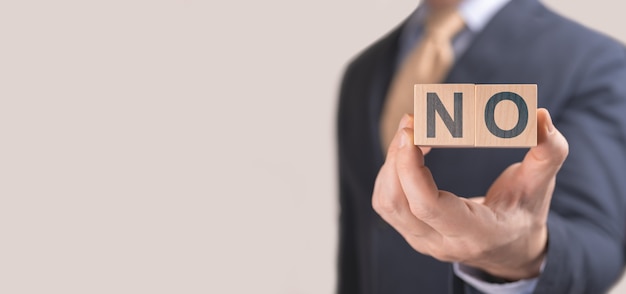 Foto torso de empresario sosteniendo un cubo de madera sin nada escrito en él