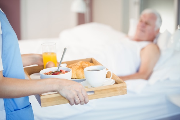 Torso de enfermera con desayuno en bandeja