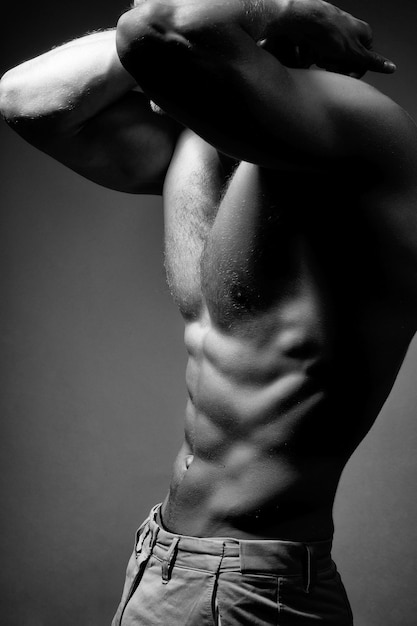 Torso masculino musculoso sexy de fisiculturista atleta posando no poder com as veias nas mãos e no peito nu ...
