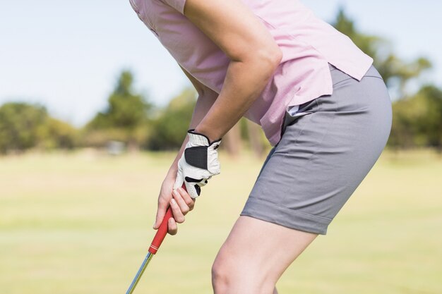 Torso de mujer jugando al golf