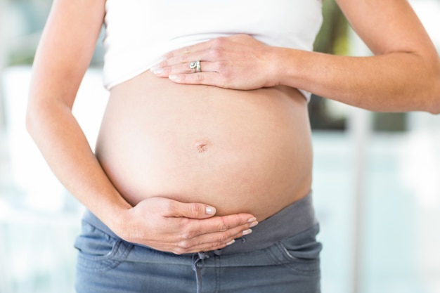 Torso de mujer con las manos en el vientre