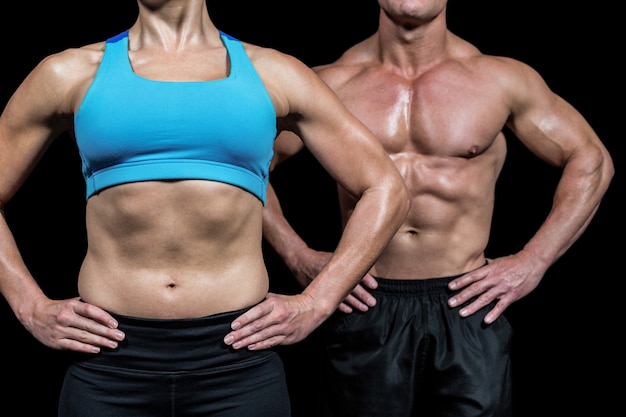 Torso de mujer muscular y hombre de pie con las manos en la cadera