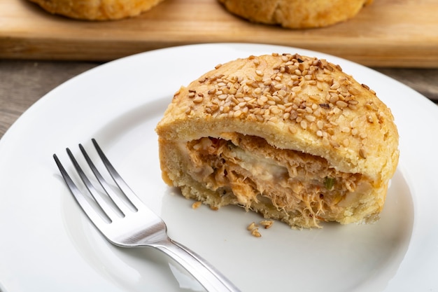 Torta caseira de frango recheado no prato branco.