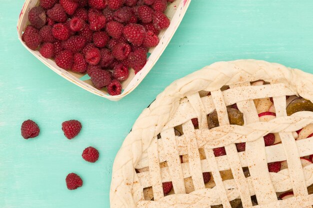 Torta caseira de frutas com framboesas na massa de fundo turquesa com frutas Assando em casa