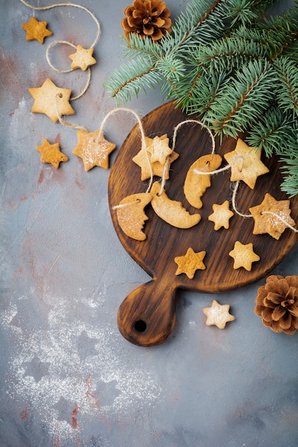 Torta casera de azúcar en forma de estrella con azúcar en polvo y rama de árbol en forma de hilo sobre la superficie de textura azul. Enfoque selectivo. Navidad o año nuevo.
