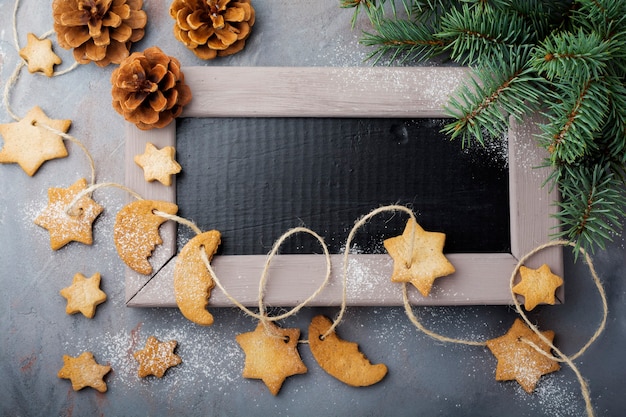 Torta casera de azúcar en forma de estrella con azúcar en polvo y rama de árbol en forma de hilo sobre la superficie de textura azul. Navidad o año nuevo. Vista superior con espacio.