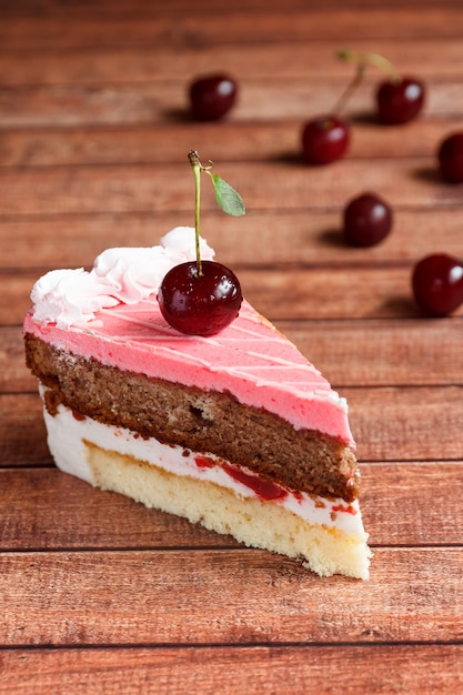 Torta de chocolate con las cerezas en fondo de madera.