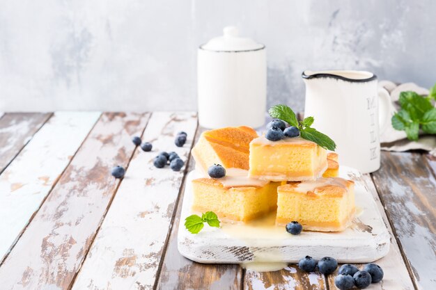 Torta cocida al horno hecha en casa tradicional del pudín con crema y arándanos de las natillas.